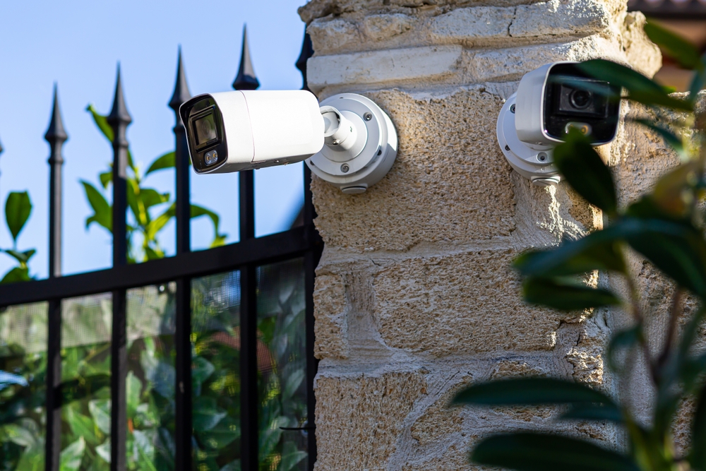 Security cameras on brick fence.